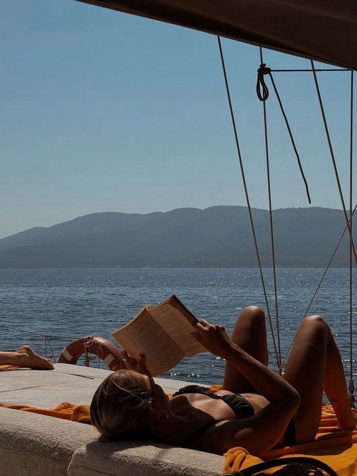 Reading on the bow of a sailboat